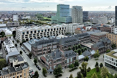 Une vue aérienne du Campus Cadix dans le quartier Cadix sur Eilandje à Anvers. Sur la photo, on voit clairement le campus rénové, avec d'une part le nouveau bâtiment pour Stemstroom (enseignement secondaire technique), et d'autre part les hangars CAD rénovés et le bâtiment Van Averbeke rénové et restauré.