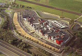 Luchtfoto van het Factory Outlet Center Rosada in Roosendaal: een modern winkelcomplex.