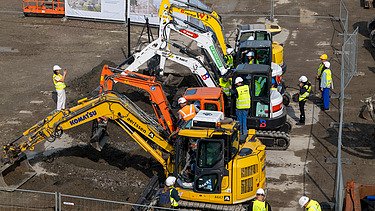 Foto van verschillende graafmachines tijdens de eerste spadesteek van de nieuwe projecten op UZ Gent.
