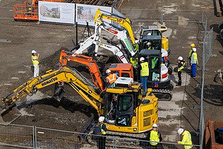 Photo de plusieurs excavateurs lors du premier coup de bêche des nouveaux projets à l'UZ Gent.