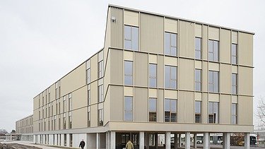 Foto van de gouden gevel van het nieuwe schoolgebouw voor VTS Sint-Niklaas.
