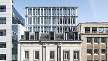 Foto van de gerestaureerde geklasseerde gevel met daarachter het nieuwe kantoorgebouw van Landesvertretung Baden-Württemberg in Brussel.
