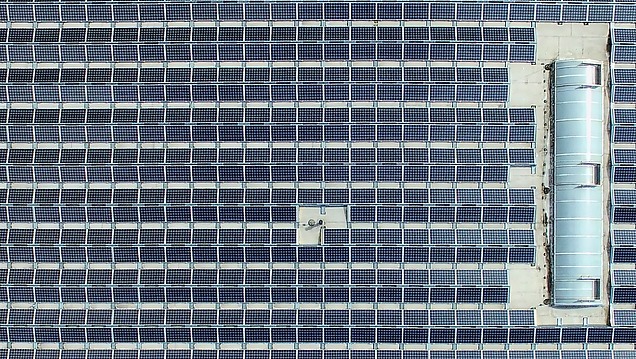 Luchtfoto van heel veel zonnepanelen op een dak.