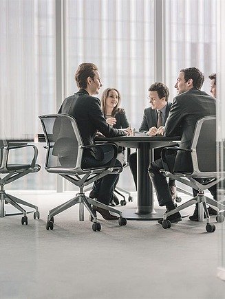 Management team in meeting. Photo of a management team sitting around a large table in a conference room.
