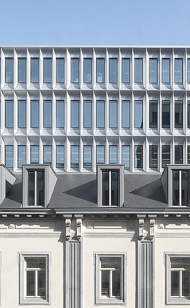 Foto van de gerestaureerde façade met daarachter het nieuwe kantoorgebouw van Landesvertretung Baden-Württemberg in Brussel.