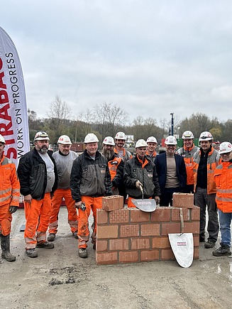 Foto van het STRABAG-team tijdens de ceremoniële eerstesteenlegging van WOL U, een grootschalig residentieel project in Zaventem.
